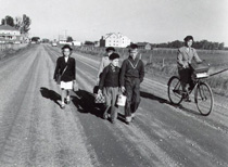 Photo en noir et blanc. Enfants marchant sur une route.
